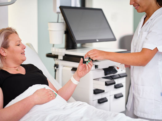 Nurse giving a patient her medicine at her bedside
